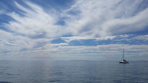 Sailboat sailing on sea against sky