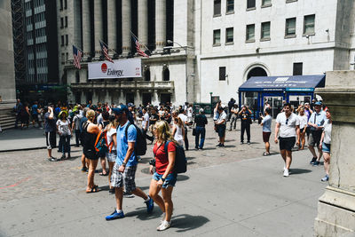 Group of people walking on street in city