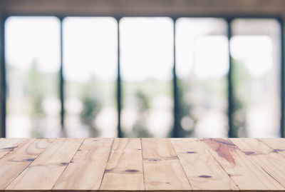 Close-up of wooden table against window