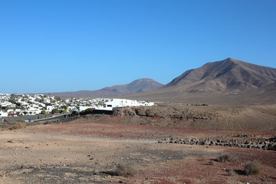 Scenic view of desert against clear blue sky