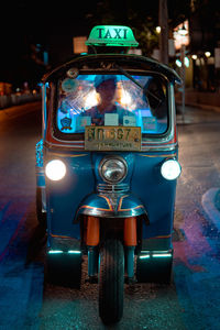 Illuminated vintage car on street at night