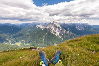 Low section of person on mountain against sky