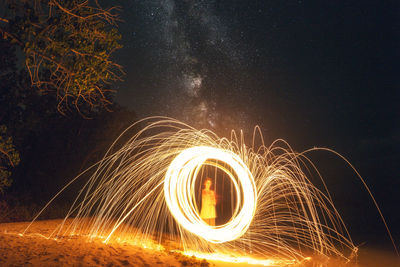 Man spinning wire wool at night