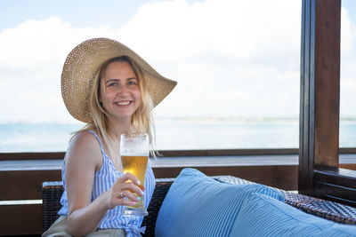 Portrait of smiling woman holding beer glass