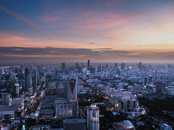 Aerial view of buildings in city against sky during sunset