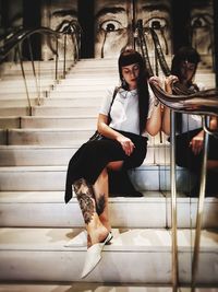 Portrait of young woman sitting on staircase