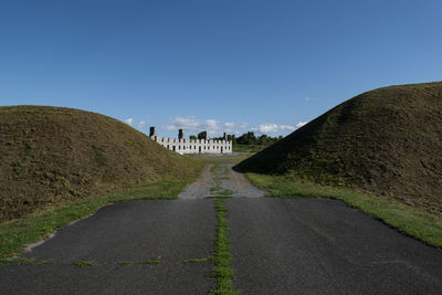 Surface level of road against clear blue sky