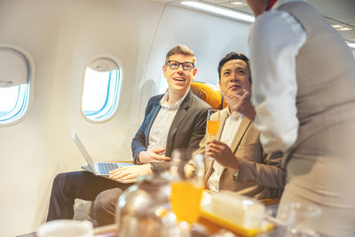 On a corporate aircraft, an air hostess serves passengers. on an airplane, a flight 