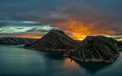 Aerial view of lake and mountain against dramatic sky