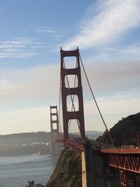 View of suspension bridge against cloudy sky