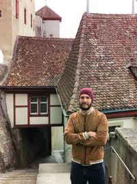 Portrait of bearded man with arms crossed standing in town
