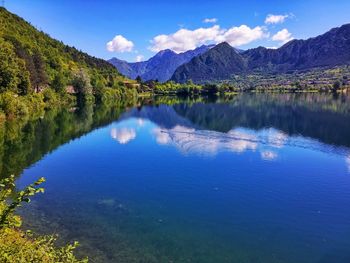 Scenic view of lake and mountains against blue sky