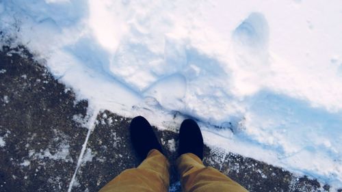 Low section of person standing on snow