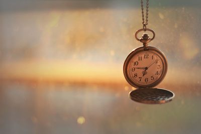 Close-up of clock hanging against blurred background