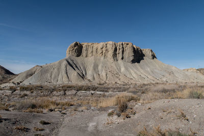 Scenic view of mountain against blue sky