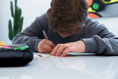 Close-up of boy studying at home