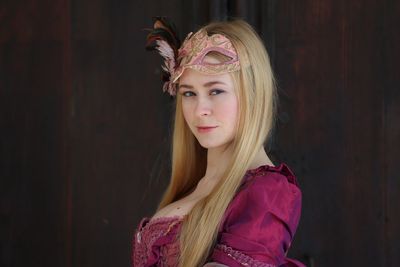 Portrait of confident young woman with mask in carnival