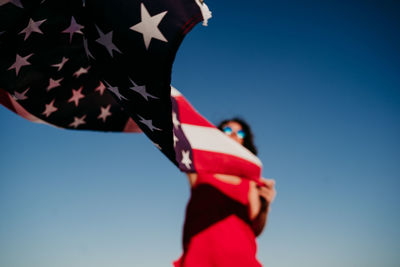 Low angle view of flag against clear blue sky