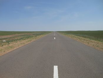 Empty road passing through field