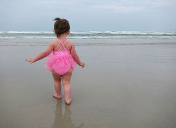 Rear view of baby girl walking on sea shore