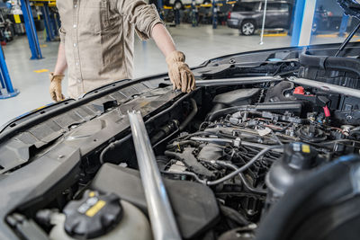 Midsection of man repairing car