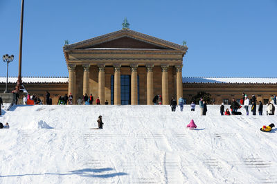 People at town square against clear blue sky