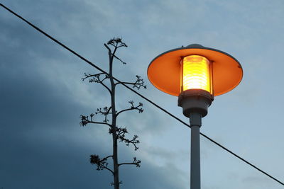 Low angle view of illuminated street light against sky