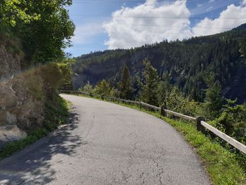 Road amidst trees against sky