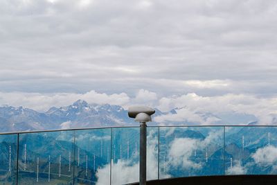 Coin-operated binoculars at observation point against sky