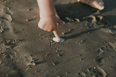 Low section of child on sand at beach