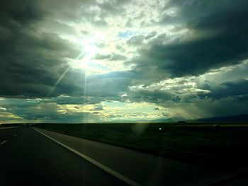 Empty road against cloudy sky