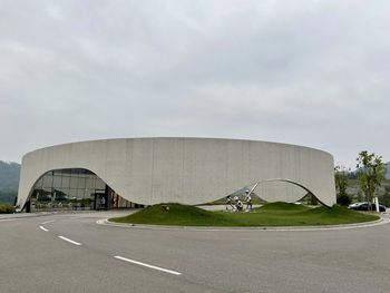 Road by building against sky