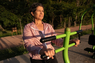 Portrait of young woman exercising in park