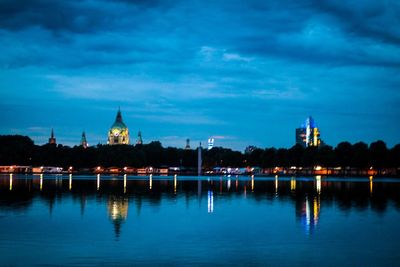 Reflection of illuminated buildings in river at dusk