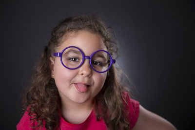 Close-up portrait of girl against black background