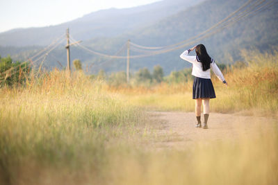 Full length of woman walking on field