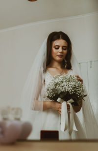 Portrait of a beautiful caucasian bride with a bouquet of boutonnieres.