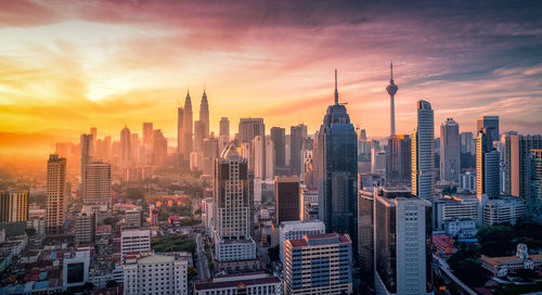 Aerial view of buildings in city during sunset