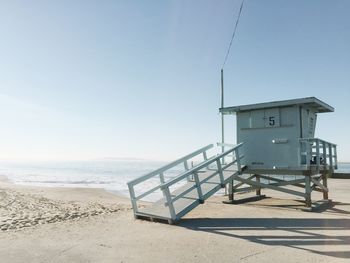 Lifeguard hut on beach against clear sky