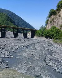 Scenic view of river by mountains against clear sky