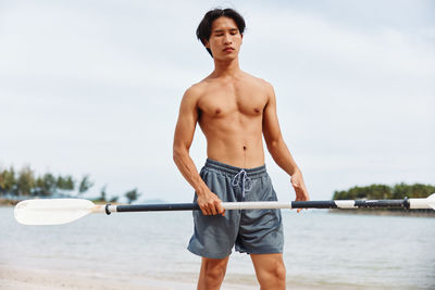 Portrait of shirtless man exercising in gym