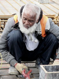 Full length of man sitting outdoors