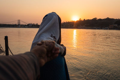 Young couple holding hands at sunset at ganges river bank from different angle