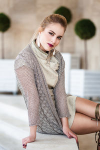Portrait of young woman sitting outdoors
