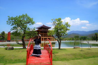 Woman in park by lake against sky