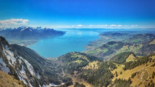 Scenic view of sea and mountains against blue sky