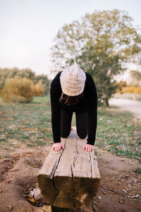 Rear view of woman wearing hat sitting outdoors
