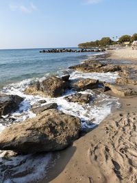 Scenic view of rocks on beach against sky