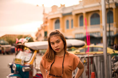 Portrait of young woman standing in city