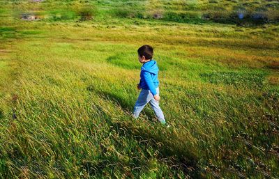 Full length of boy walking on grassy field